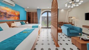 A hotel room with two beds, a large painting, a balcony, and a modern chandelier. - An Cuu Residence (Hue)