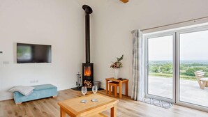 Een moderne woonkamer met een open haard, een bank, een salontafel en een televisie.