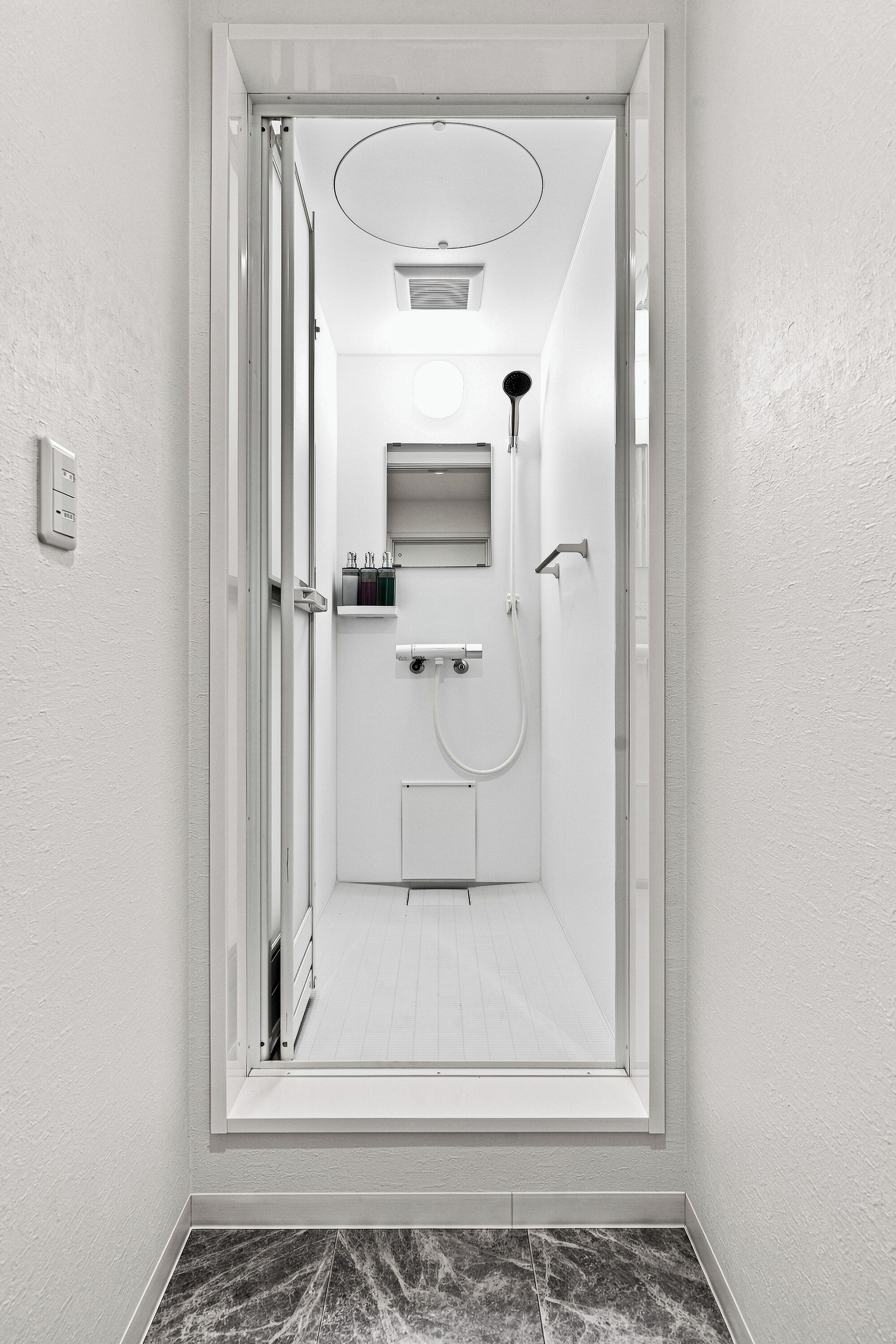 A modern bathroom with a shower, toilet, and sink.