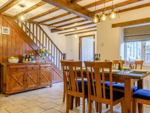 A dining area with wooden furniture, a staircase, and a view of the outside. - 4 Bed in Matlock (oc-85450) (Brassington)