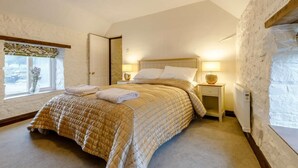 A bedroom with a large bed, bedside tables, a radiator, and a window with a view. - 4 Bed in Matlock (oc-85450) (Brassington)