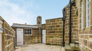 A stone courtyard with a door, a window, and a chimney. - 3 Bed in Whitby (oc-85927) (Fylingdales)