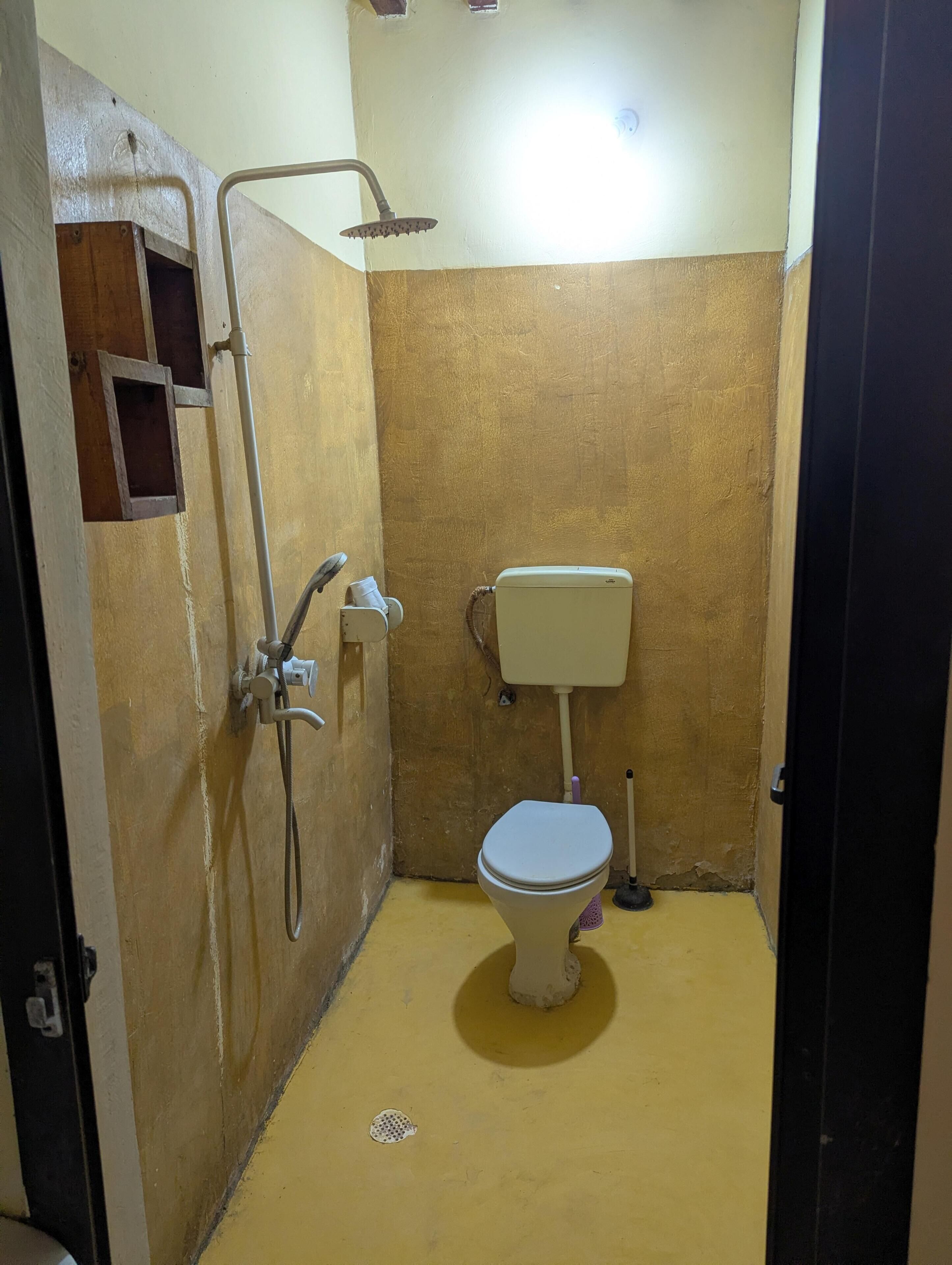 Un baño pequeño y funcional con inodoro, ducha y lavamanos.