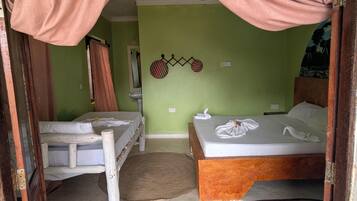 A room with two beds, a small table, and a wall-mounted bicycle decoration.
