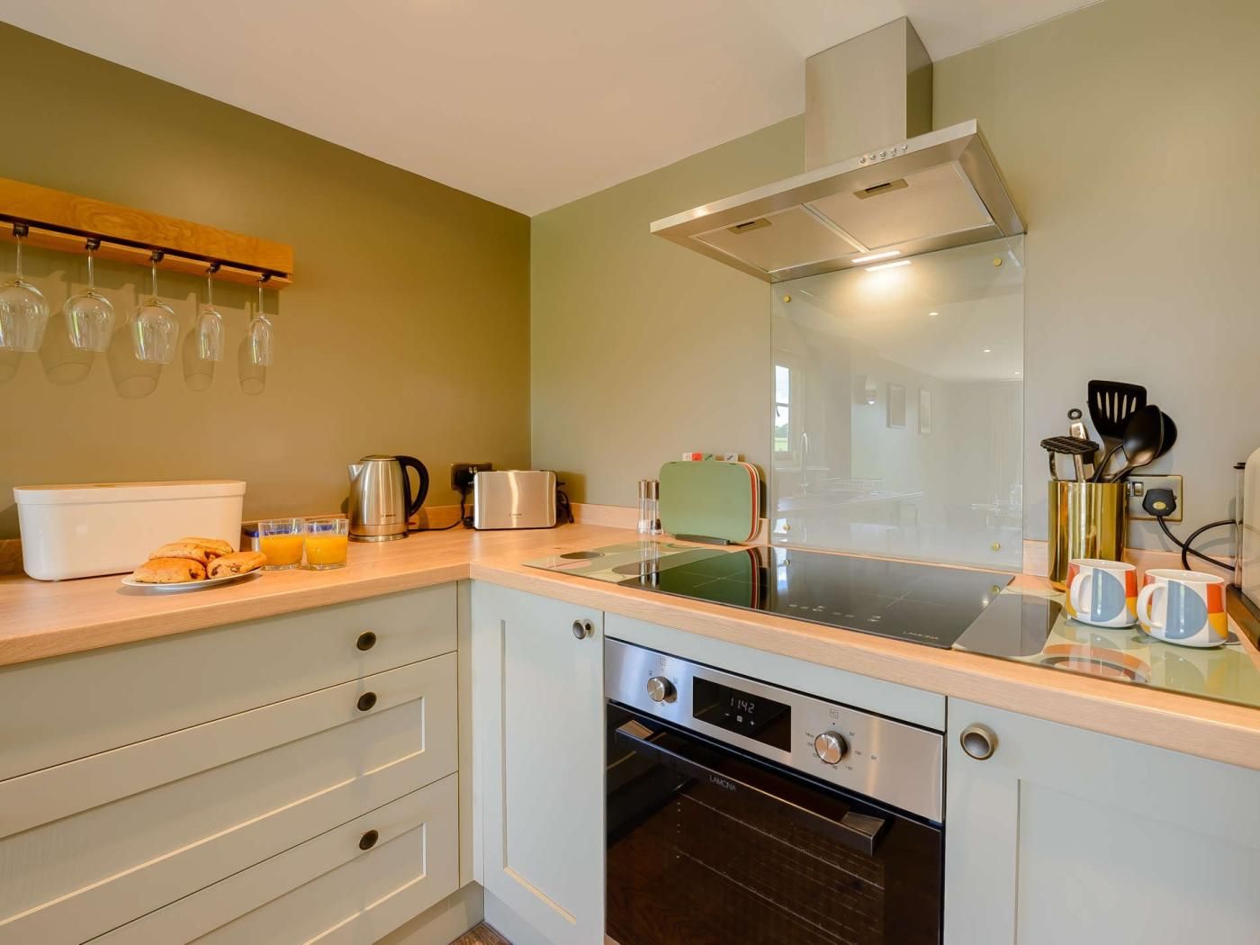 Eine moderne Küche mit Backofen, Kaffeemaschine und Wasserkocher auf der Arbeitsfläche.