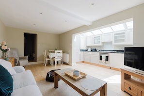 A modern living room with a sofa, coffee table, and a TV stand. - Chic 2BDR Retreat in Wandsworth Town (Greater London)