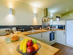 A modern kitchen with a wooden countertop, a built-in oven, and a microwave. - 2 Bed in Newark (oc-88428) (Perlethorpe)