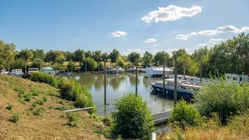A marina with boats docked, surrounded by greenery and trees.