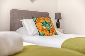 A neatly made bed with white linens and a single decorative pillow with a leopard print design. - 6 Bed in Holsworthy (oc-89218) (Holsworthy Hamlets)