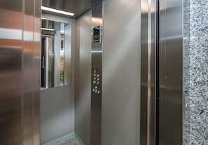 A modern elevator with stainless steel doors and a digital display. - Corporate Stays Insignia 4 - A63 (Lúke)