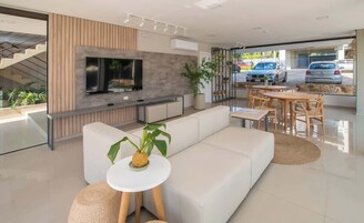 Una sala de estar moderna con sofá, televisión y comedor.