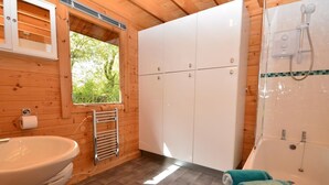 A wooden cabin bathroom with a toilet, sink, cabinets, a window, and a shower. - 1 Bed in Bodmin (oc-brilo) (Tredinnick Pits)