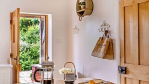 A kitchen with a coffee maker, bread, and a basket of flowers. - 3 Bed in Kingsbridge (oc-court) (South Huish)