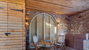 A log cabin with a stone wall, a wooden door, and a stone floor. - 2 Bed in Settle (oc-g0051) (Settle)
