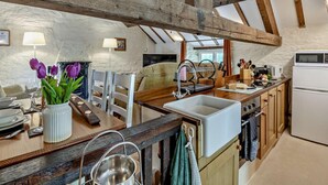 A rustic kitchen with exposed wooden beams, a sink, a stove, and a dining area with a table and chairs. - 1 Bed in Sheffield (oc-pk417) (Sheffield)