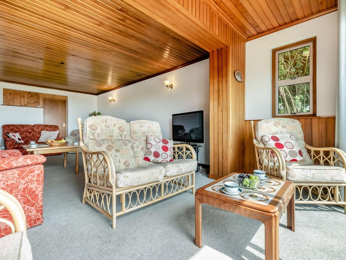 A cozy living room with a sofa, chairs, a coffee table, and a television.