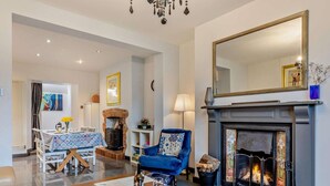 A living room with a fireplace, a dining area, and a large mirror. - 2 Bed in Wells (oc-wesba) (Wookey Hole)