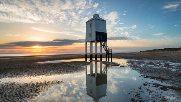 A lighthouse on a beach with a clear sky and sunset. - 2 Bed in Wells (oc-wesba) (Wookey Hole)