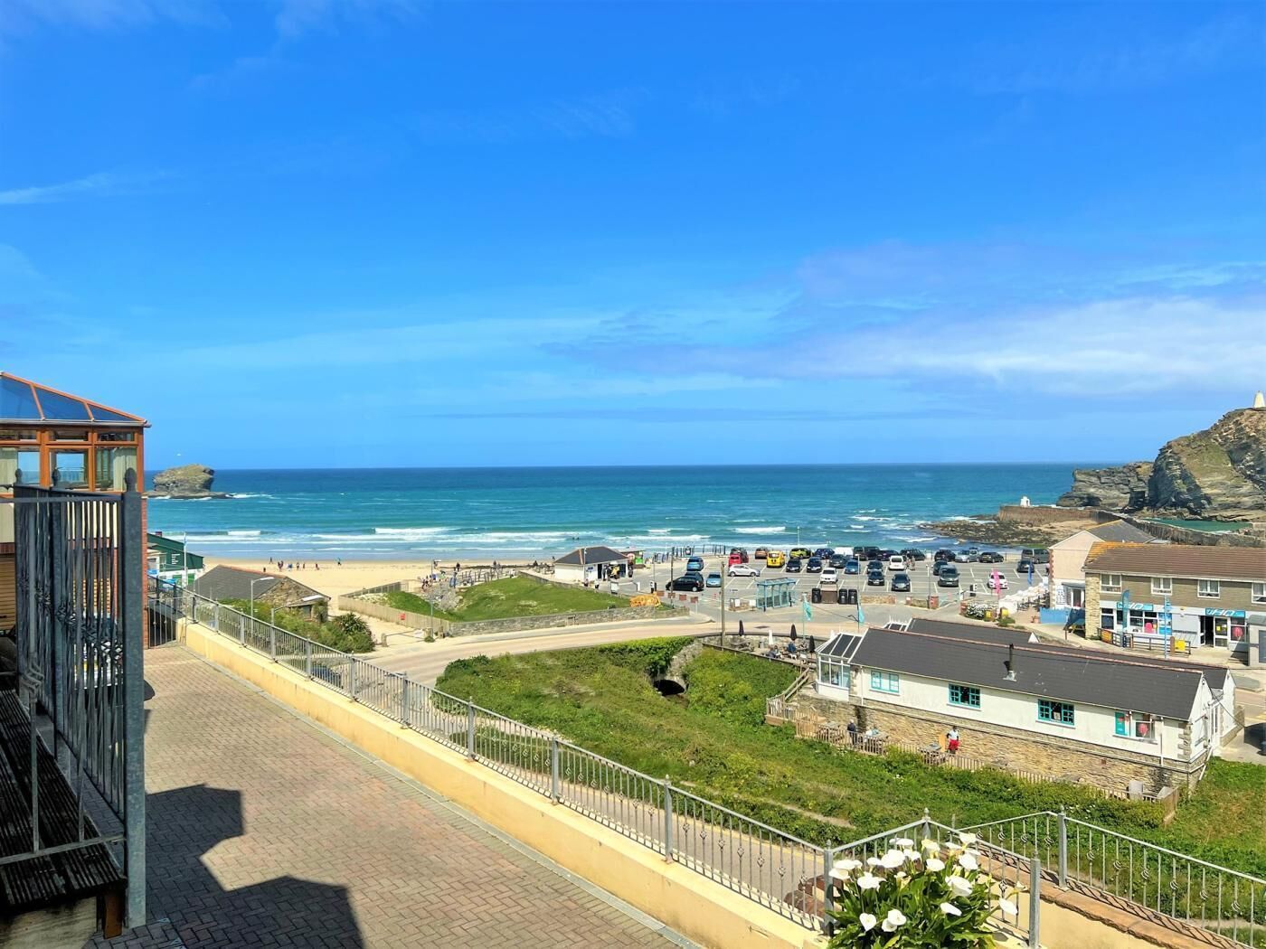 Uma cidade costeira com uma praia, um farol e um parque de estacionamento.