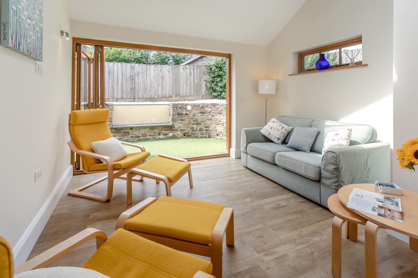 A living room with a sofa, a yellow armchair, and a coffee table.