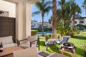 An outdoor seating area with a pool view, lounge chairs, and a barbecue grill. - Holiday Home 'Casa Thomas II Terraced Corner' with Shared Pool, Wi-Fi and Air Conditioning (Roda)