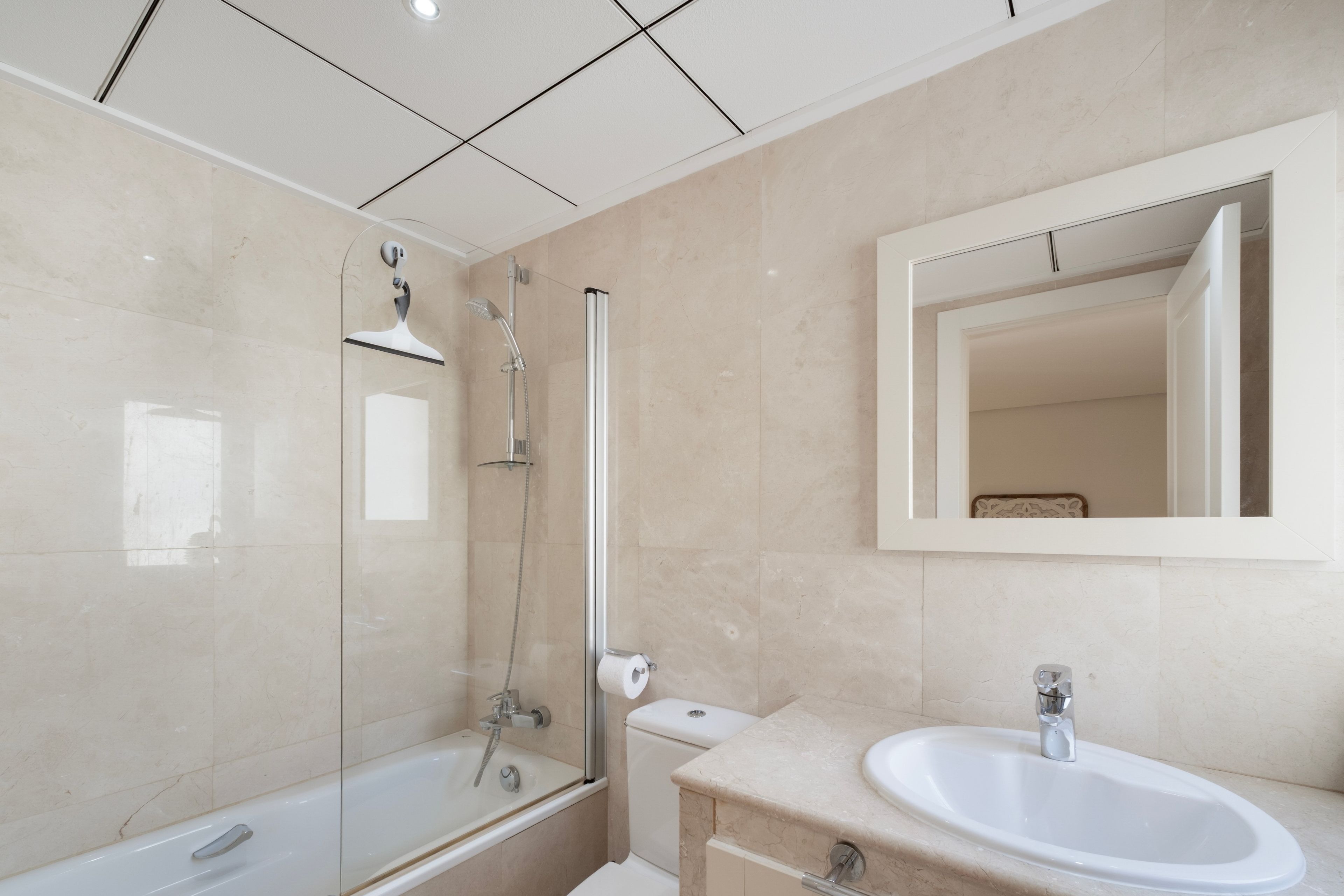 Un baño moderno con una bañera, ducha, inodoro y lavamanos.