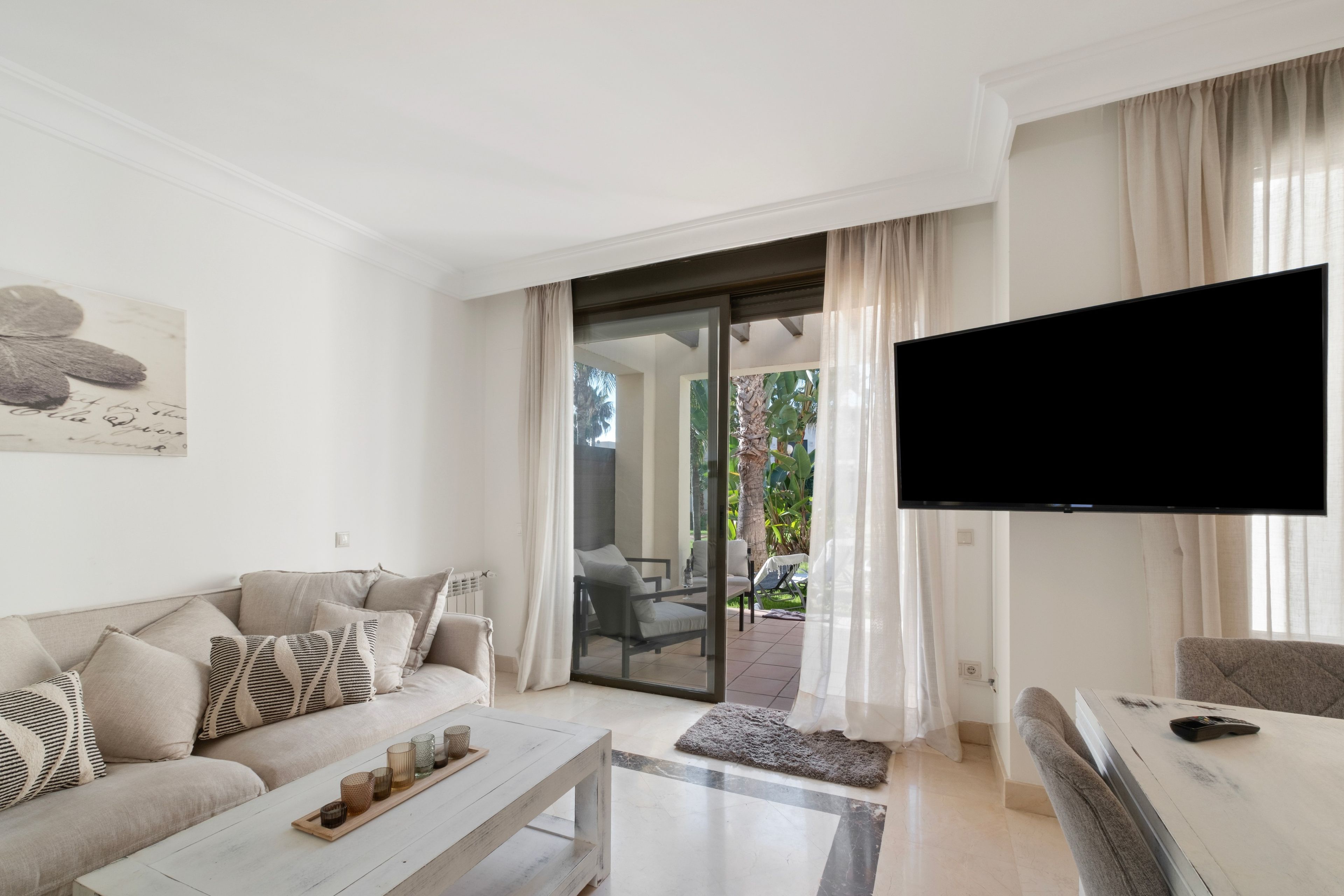 Una sala de estar moderna con un sofá, una mesa de centro y un televisor de pantalla plana.