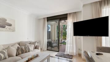 Una sala de estar moderna con un sofá, una mesa de centro y un televisor de pantalla plana.