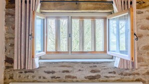 A stone wall with a window featuring a wooden frame and a curtain rod. - 2 Bed in Crickhowell (oc-42920) (Llangattock)