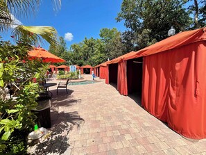 A pathway lined with red tents, a pool, and outdoor seating. - Galactic Oasis in Kissimmee (Davenport)