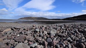 A rocky beach with a clear sky and distant hills. - 3 Bed in Minehead (oc-44078) (Porlock)