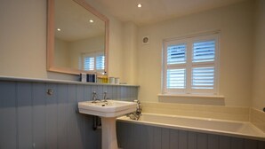 Un baño con un lavamanos blanco, un inodoro y una bañera.