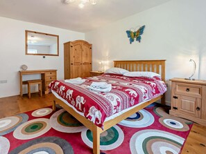 Ein Schlafzimmer mit Bett, Schreibtisch, Kleiderschrank, Spiegel und einer Schmetterlingsdekoration.