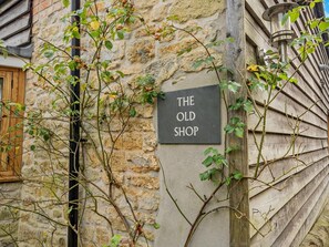 A stone wall with a sign reading 'THE OLD SHOP' and a wooden shutter. - 1 Bed in Gillingham (oc-46774) (Bourton)