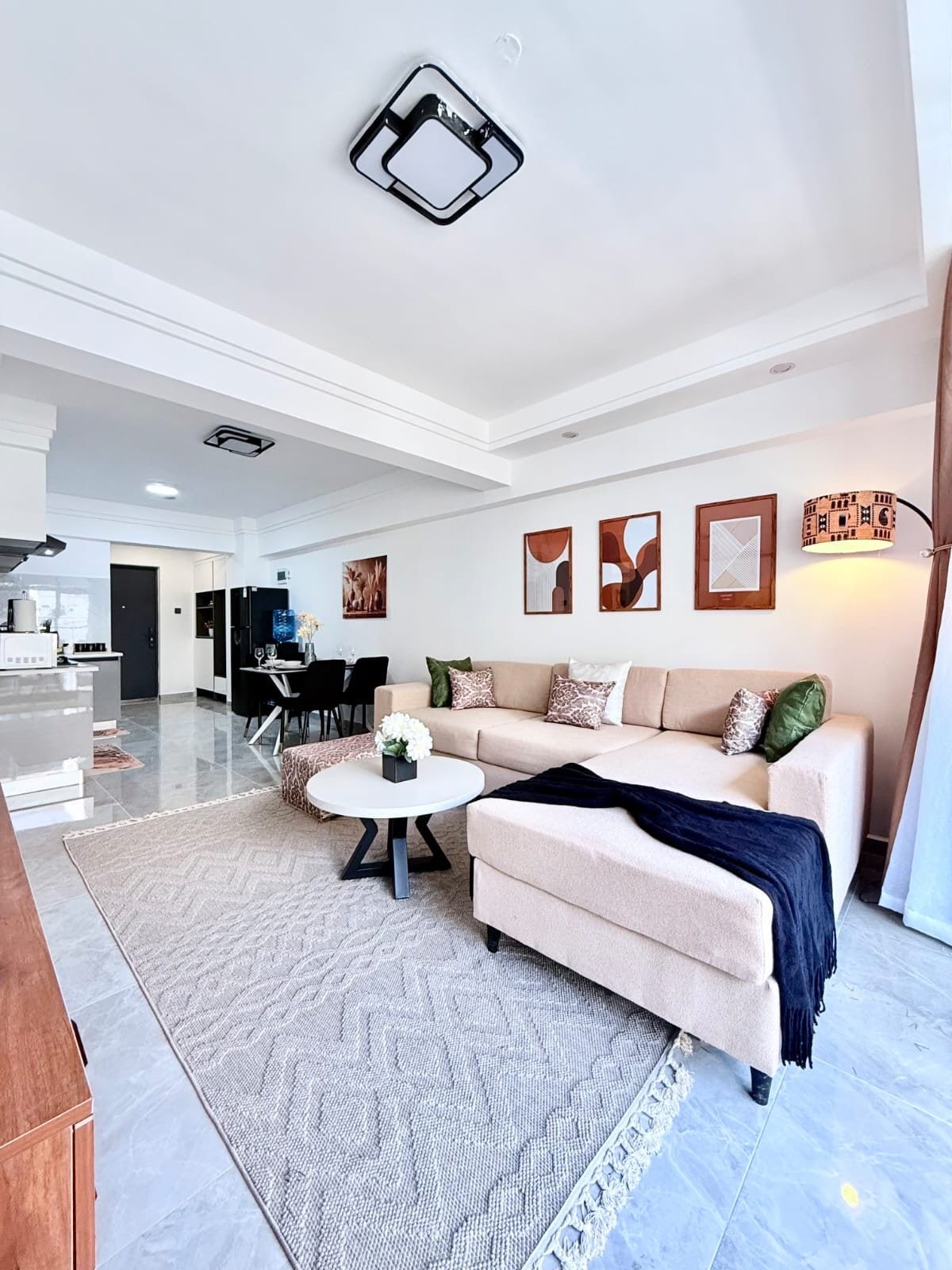 Een moderne woonkamer met een bank, salontafel en kunstwerken aan de muur.
