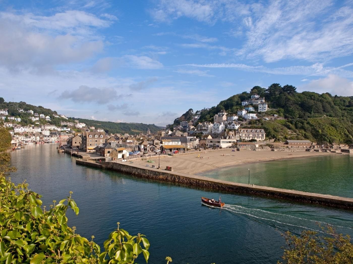 A coastal town with a marina, sandy beach, and residential buildings.