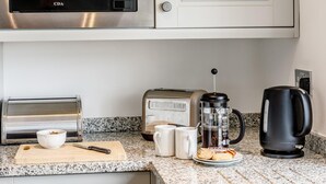 A kitchen with a microwave, toaster, coffee maker, and a cutting board with a knife. - 1 Bed in Sheffield (oc-48259) (Thurlstone)