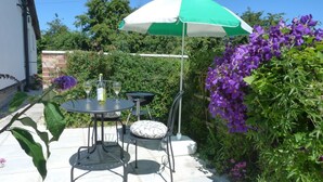 An outdoor patio with a table, chairs, a grill, and a green and white umbrella. - 1 Bed in Taunton (oc-49569) (North Curry)