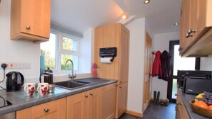 A modern kitchen with wooden cabinets, a stainless steel sink, and a coffee maker. - 1 Bed in Taunton (oc-49569) (North Curry)