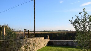 A stone wall, a grassy lawn, and a clear blue sky. - 1 Bed in Taunton (oc-49569) (North Curry)