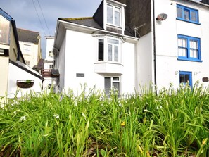 A white building with a black roof, blue windows, and a sign that reads 'Alison Cottage.' - 2 Bed in Ilfracombe (oc-49673) (Ilfracombe)