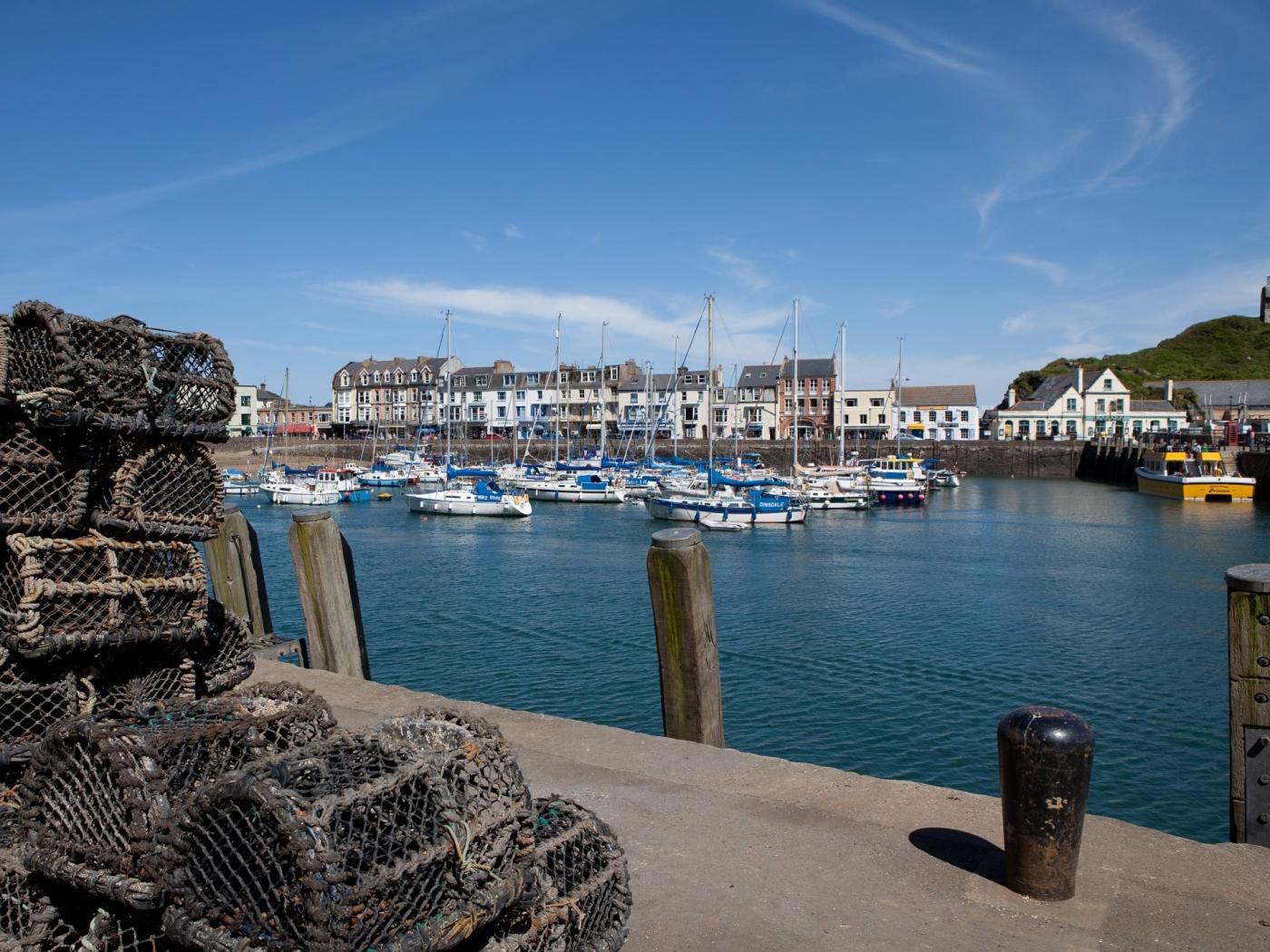 A harbor with boats, a wooden fence, and buildings in the background.