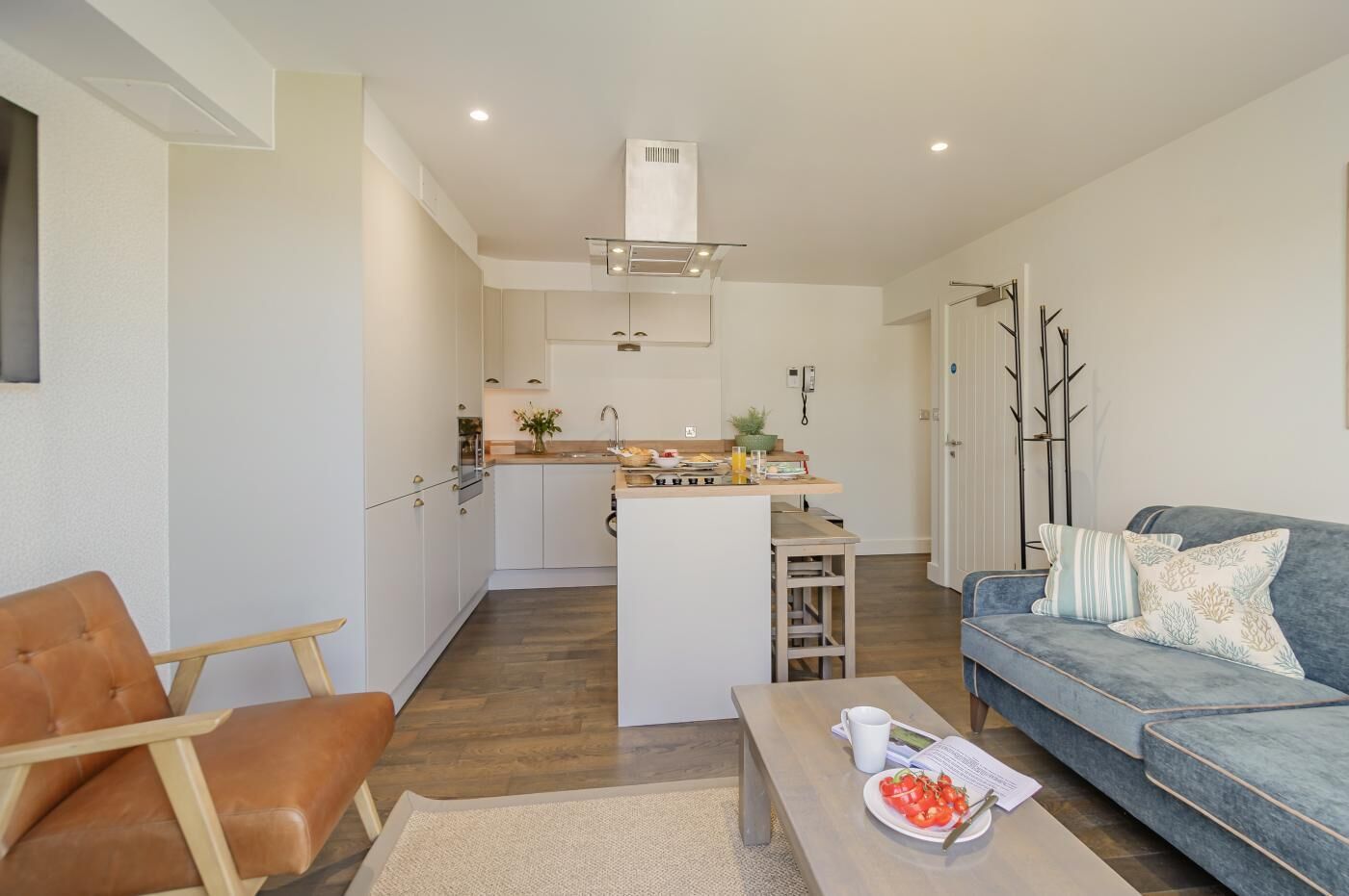 A modern apartment with a kitchen, dining area, and living room.