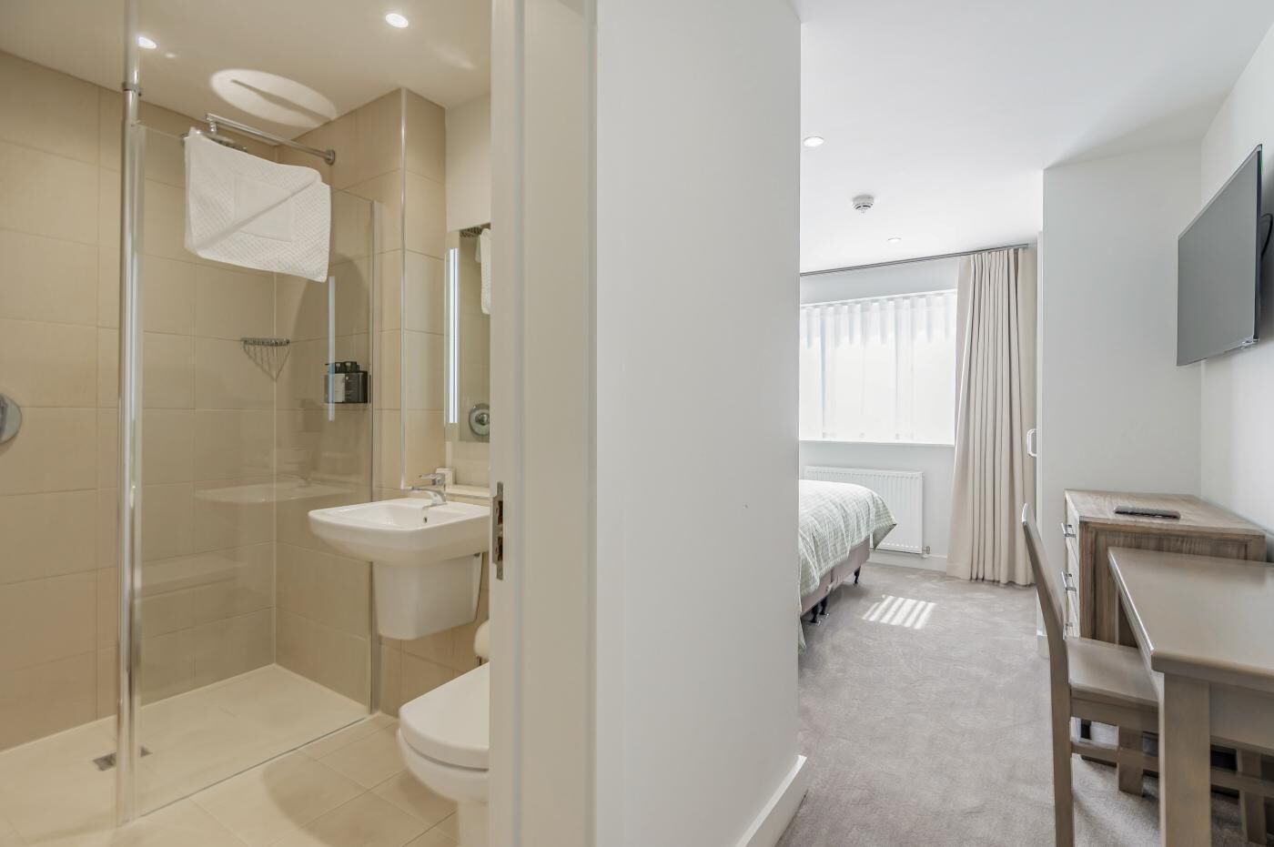 Une salle de bain moderne avec une douche à parois de verre, un lavabo et des toilettes.