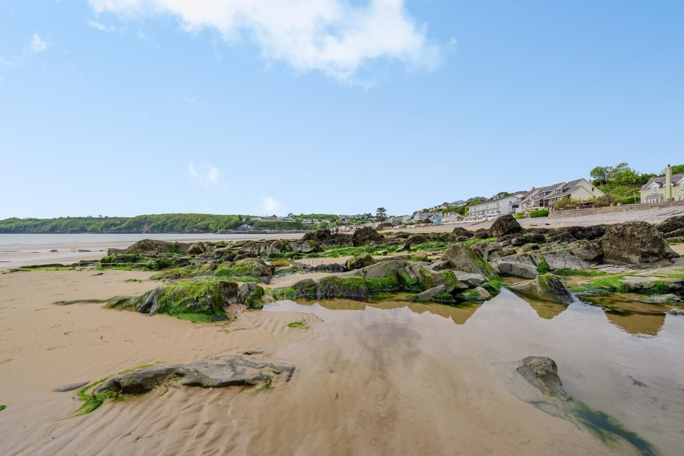 Une plage avec des formations rocheuses et un ciel dégagé.