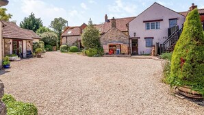A rural setting with a gravel driveway, stone buildings, and a small wooden structure. - 2 Bed in Wedmore (oc-51339) (Middle Stoughton)