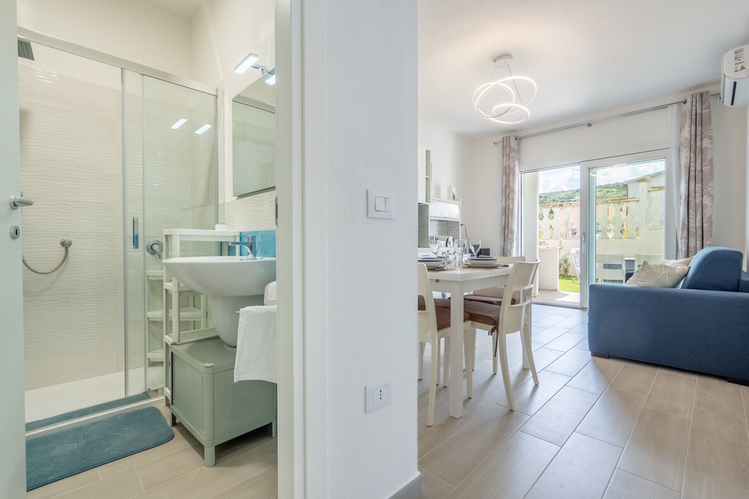 Un bagno moderno con cabina doccia in vetro, un lavandino e uno specchio.