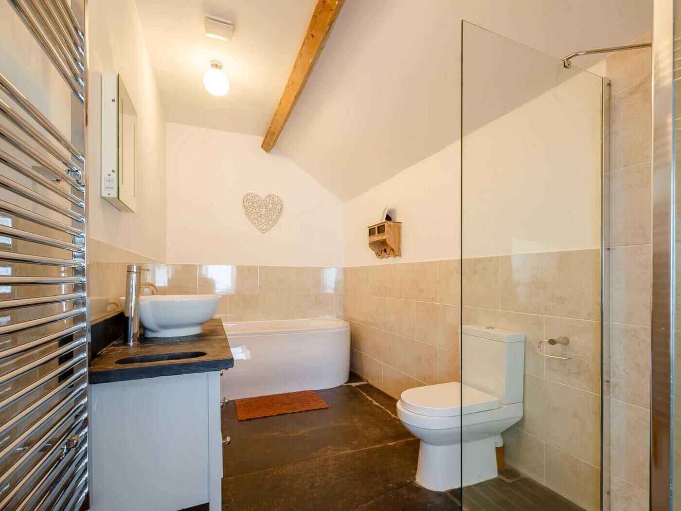 Ein modernes Badezimmer mit Badewanne, Toilette und Duschkabine aus Glas.
