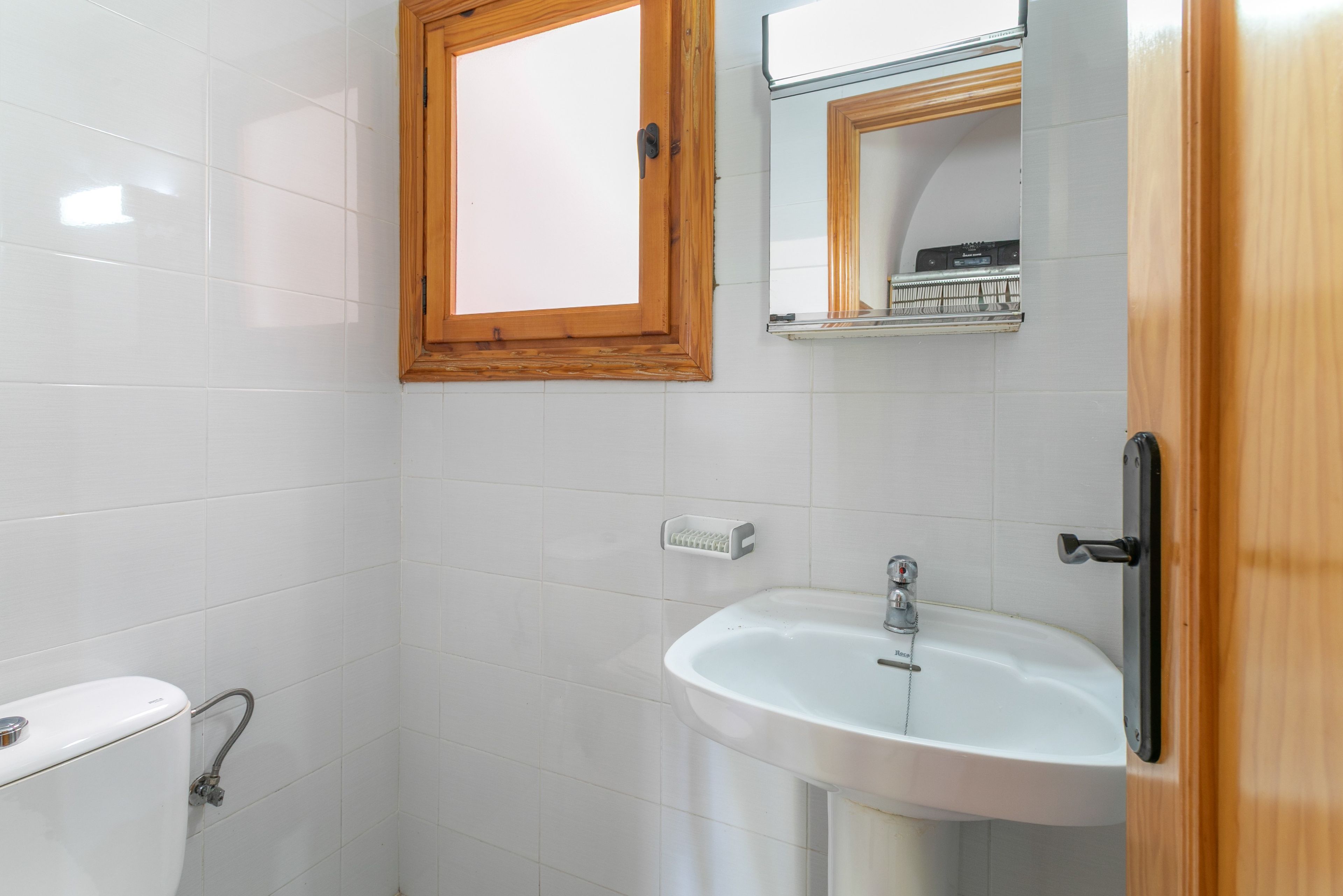 A bathroom with a toilet, a sink, and a mirror.