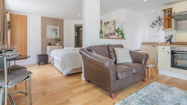 Eine moderne Wohnung mit Wohnbereich, Essbereich, Küchenzeile und Schlafzimmer.